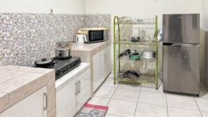A compact kitchen with a microwave, stove, and stainless steel refrigerator. - Large Villa 3BR Cieumbuleuit near PVJ & Cihamplas (Cidadap)