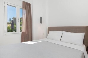A bedroom with a bed, a window with curtains, and a view of greenery outside. - Aliki's Summerhouse 1 (Argassi)