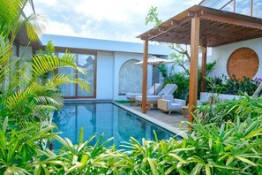 A modern pool area with lounge chairs, a pergola, and lush greenery. - Villa Moon Orchid - 3 bedroom villa (Bali)