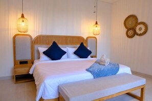 A bedroom with a wooden bed, two bedside lamps, a bench, and wall decor. - Villa Moon Orchid - 3 bedroom villa (Bali)