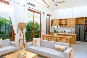 Una sala de estar moderna con un sofá, una mesa de centro y vistas a la cocina.