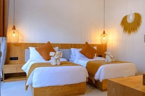 Una habitación de hotel con dos camas, cabeceros de madera y lámparas colgantes.