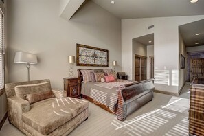 A spacious bedroom with a large bed, a sofa, and a nightstand. - Ski-in/Ski-out Penthouse Condo w/ Hot Tub + Views (Park City)