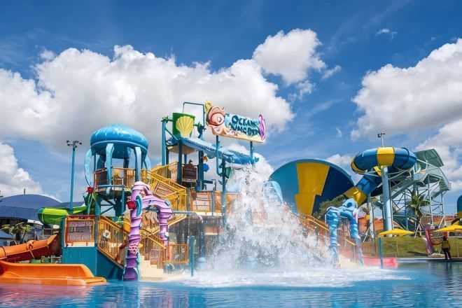 A water park with a large water slide and a sign that reads 'Ocean Magic.'