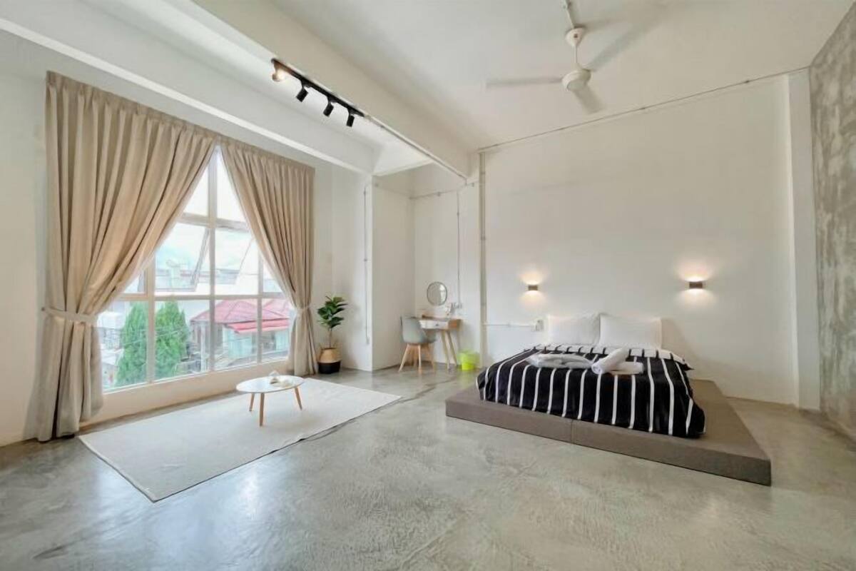 Un dormitorio moderno con una cama, un escritorio y una silla.
