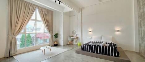 A modern bedroom with a bed, a desk, and a chair.