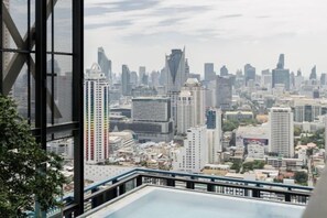A cityscape view from a high-rise building with a pool in the foreground.
