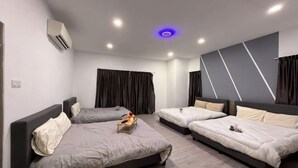 Een moderne hotelkamer met drie bedden, een flatscreen televisie en een wandairconditioner.
