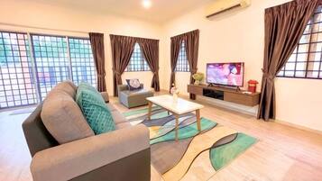 A living room with a sofa, a coffee table, and a TV.