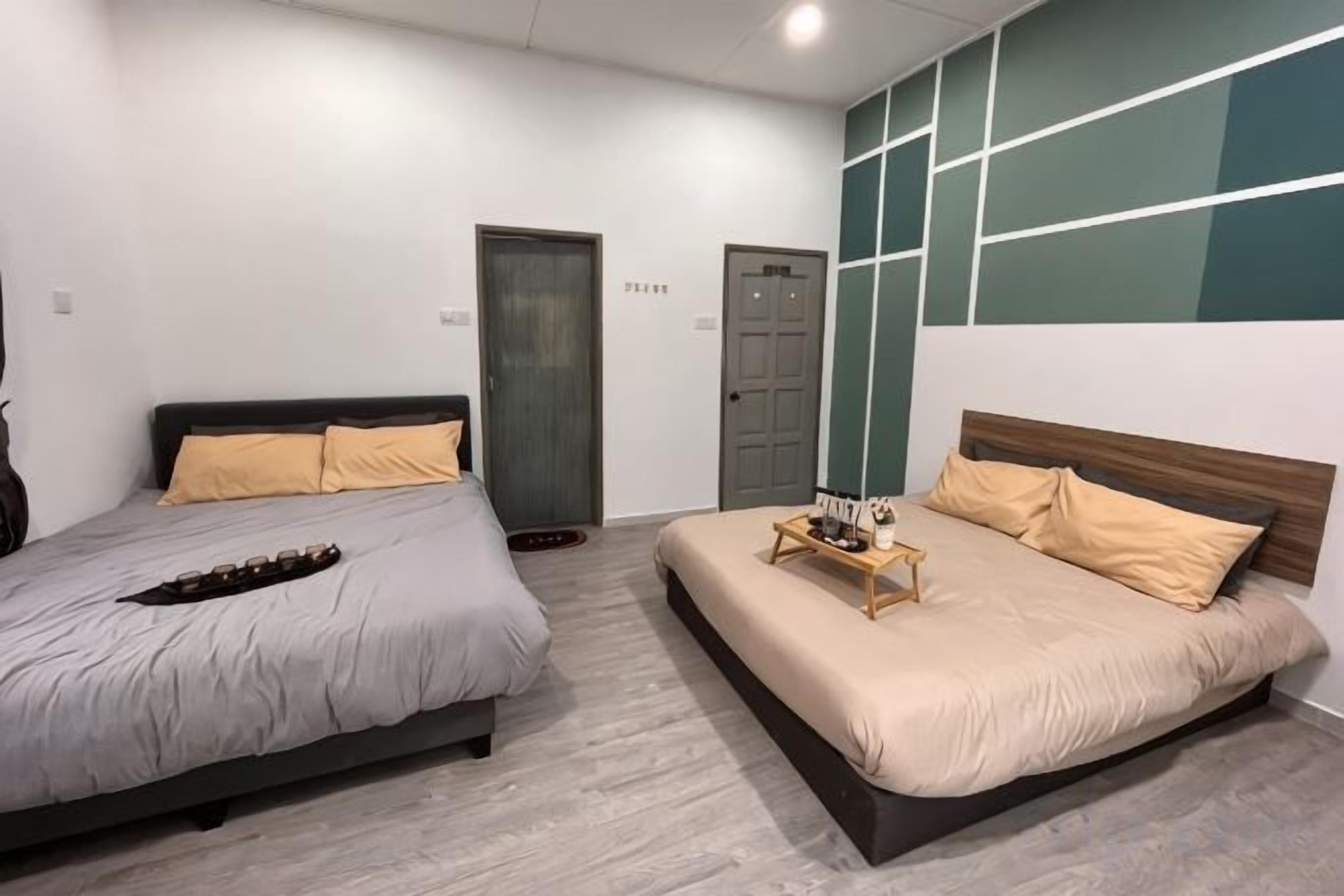 A bedroom with two beds, a wooden headboard, and a wall-mounted shelf.