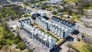 Ett modernt bostadskomplex med flera byggnader, parkeringsområden och grönområden.