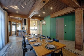 A dining area with a long wooden table set for a meal, surrounded by chairs. - Park-Hotel "Zarechye" (Glubokoye District)