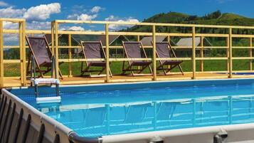 Une piscine avec des chaises longues et une vue sur les collines.