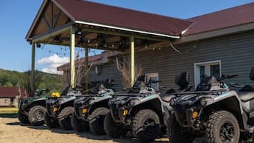 Une rangée de quads est stationnée devant un bâtiment doté d’une zone abritée.