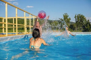 Una piscina con gente jugando con una pelota.