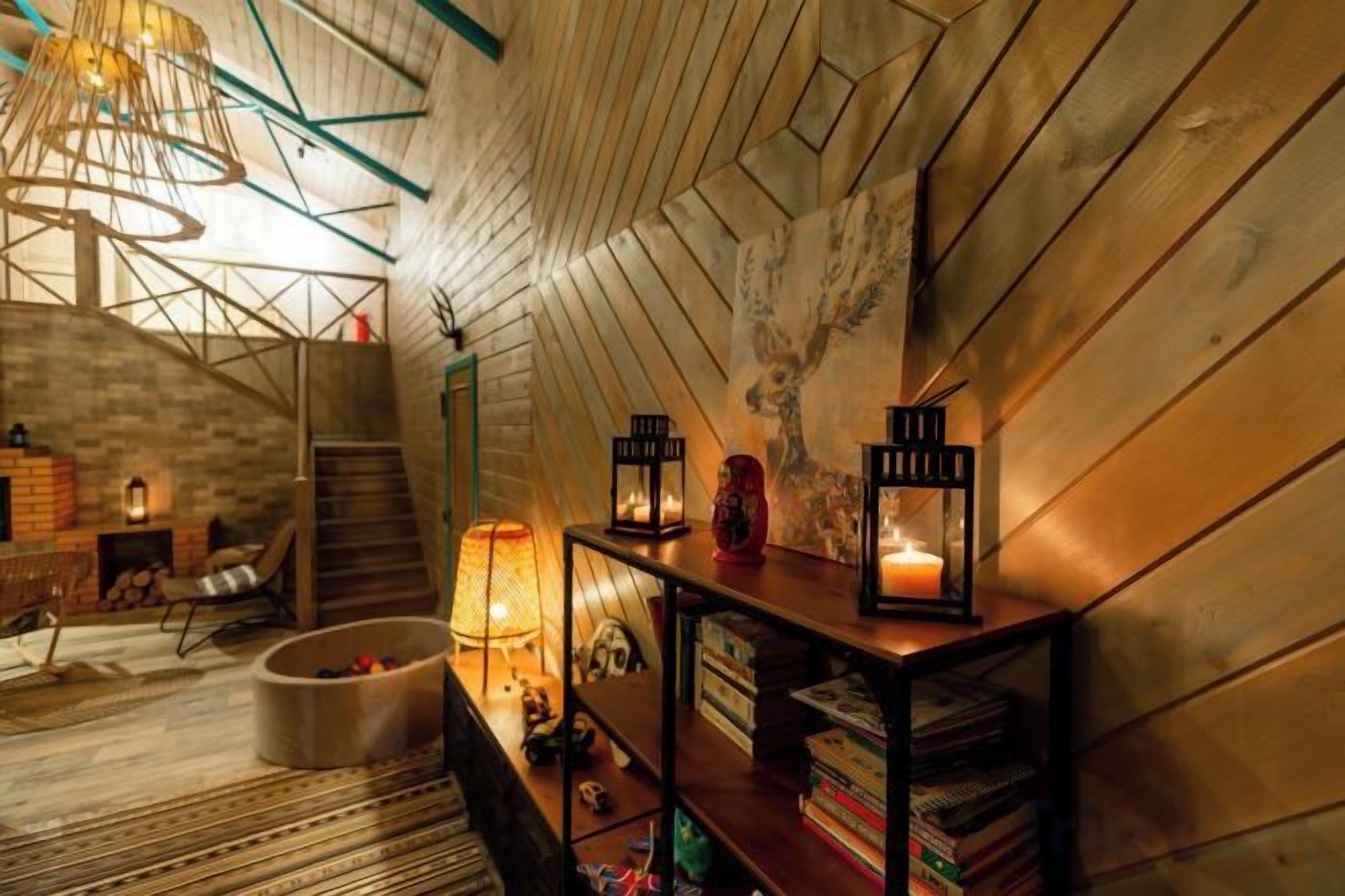 Ein Dachzimmer mit geneigter Decke, Holzwänden, einer Wendeltreppe und einem Bücherregal mit Büchern und Dekoration.