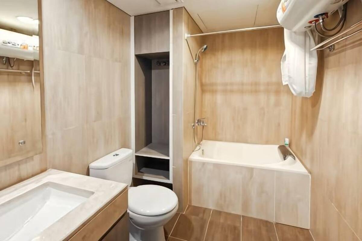 A modern bathroom with a bathtub, toilet, and walk-in shower.