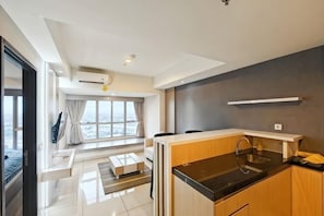 Una cocina moderna con encimera negra, armarios de madera y una ventana con cortinas.