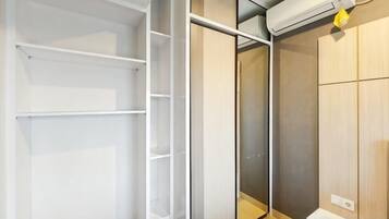 Un closet espacioso con estantes abiertos, un closet con puerta corrediza y un calentador integrado.