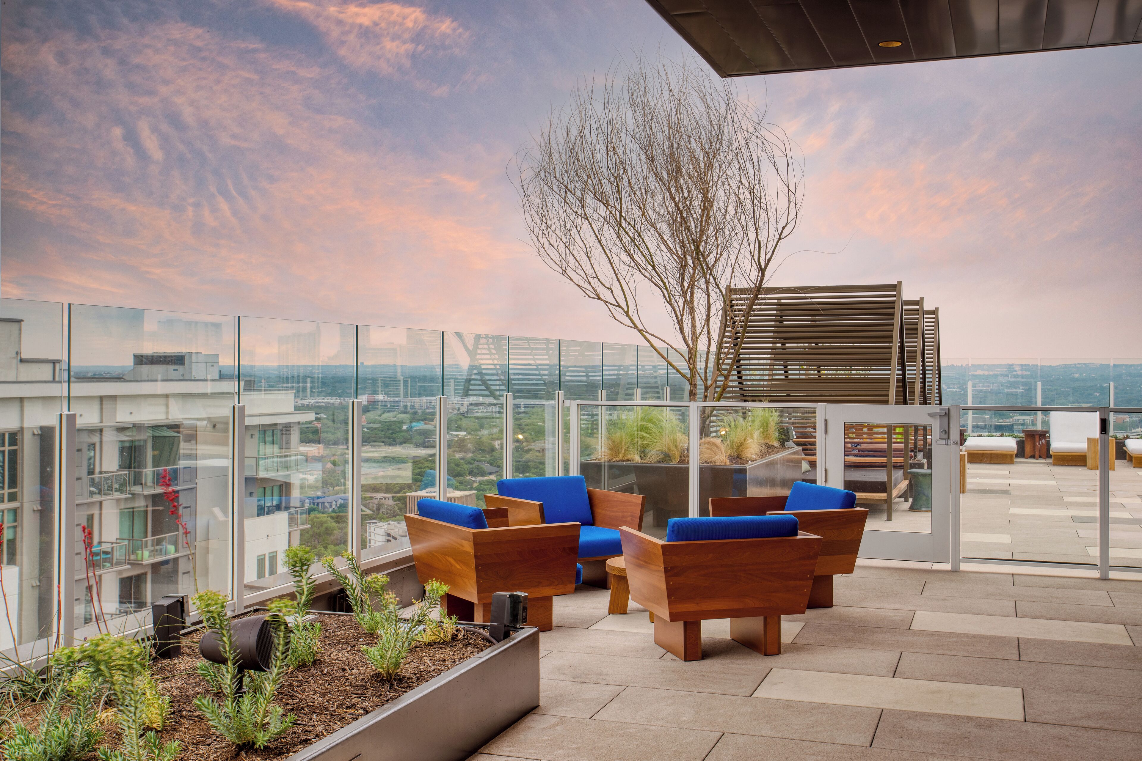 Une terrasse sur le toit, aménagée avec du mobilier en bois et offrant une vue sur le paysage urbain.