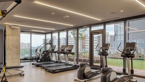 Een moderne sportschool met loopbanden, elliptische trainers en een ruimte voor yoga.