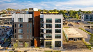 A multi-story building with a mix of modern and traditional architecture, featuring balconies and large windows. - Deluxe Four-Bedroom Suite + Balcony | The Carter (Nashville)