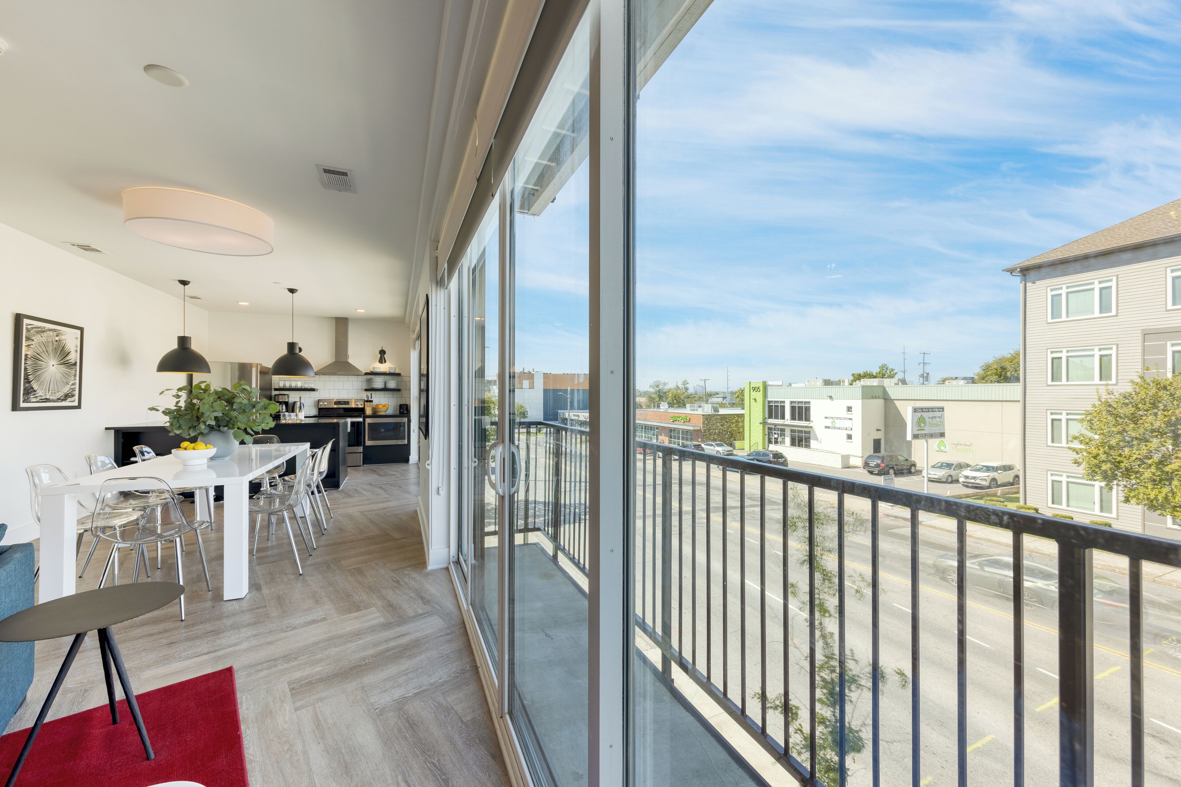 Een modern appartement met balkon, een eethoek en een keuken.