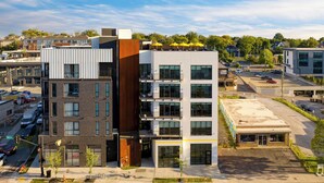 A multi-story building with a mix of modern and traditional architecture, featuring balconies and large windows. - Premier Four-Bedroom Suite + Balcony | The Carter (Nashville)