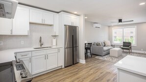 A modern kitchen with white cabinets, a stainless steel refrigerator, and a built-in oven. - Sleeps 48, Entire Hotel, Group Retreat | The Nomad (Nashville)
