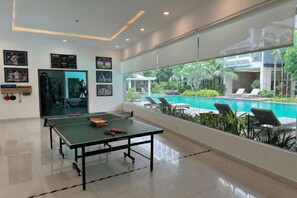 A room with a ping pong table, a pool view, and a door leading to a balcony. - Laguna beach resort Maldives 3 - Pool view studio in Pattaya jomtien (Pattaya)