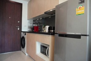 Una cocina compacta con lavadora, horno integrado y refrigerador.
