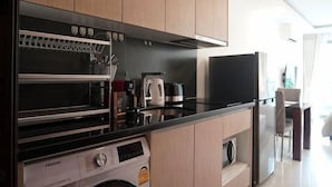 Une cuisine équipée d’un four encastré, d’un four à micro-ondes et d’une machine à café.