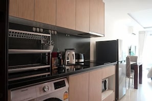 Cozinha equipada com forno embutido, micro-ondas e máquina de café.