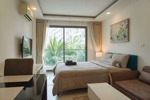 Een hotelkamer met een bed, een slaapbank, een bureau en een televisie.