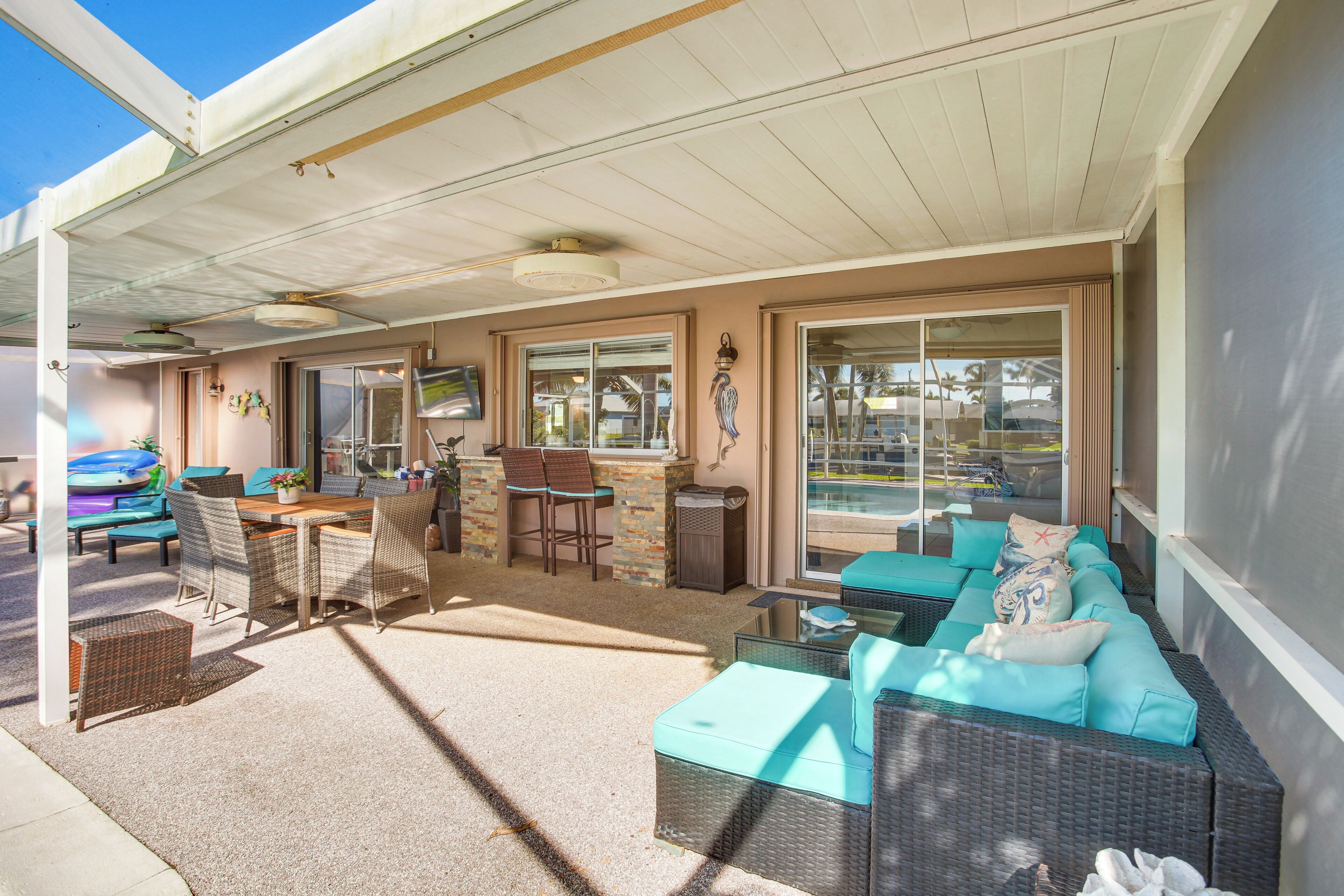 A covered patio area with wicker furniture, a bar, and a view of the street.