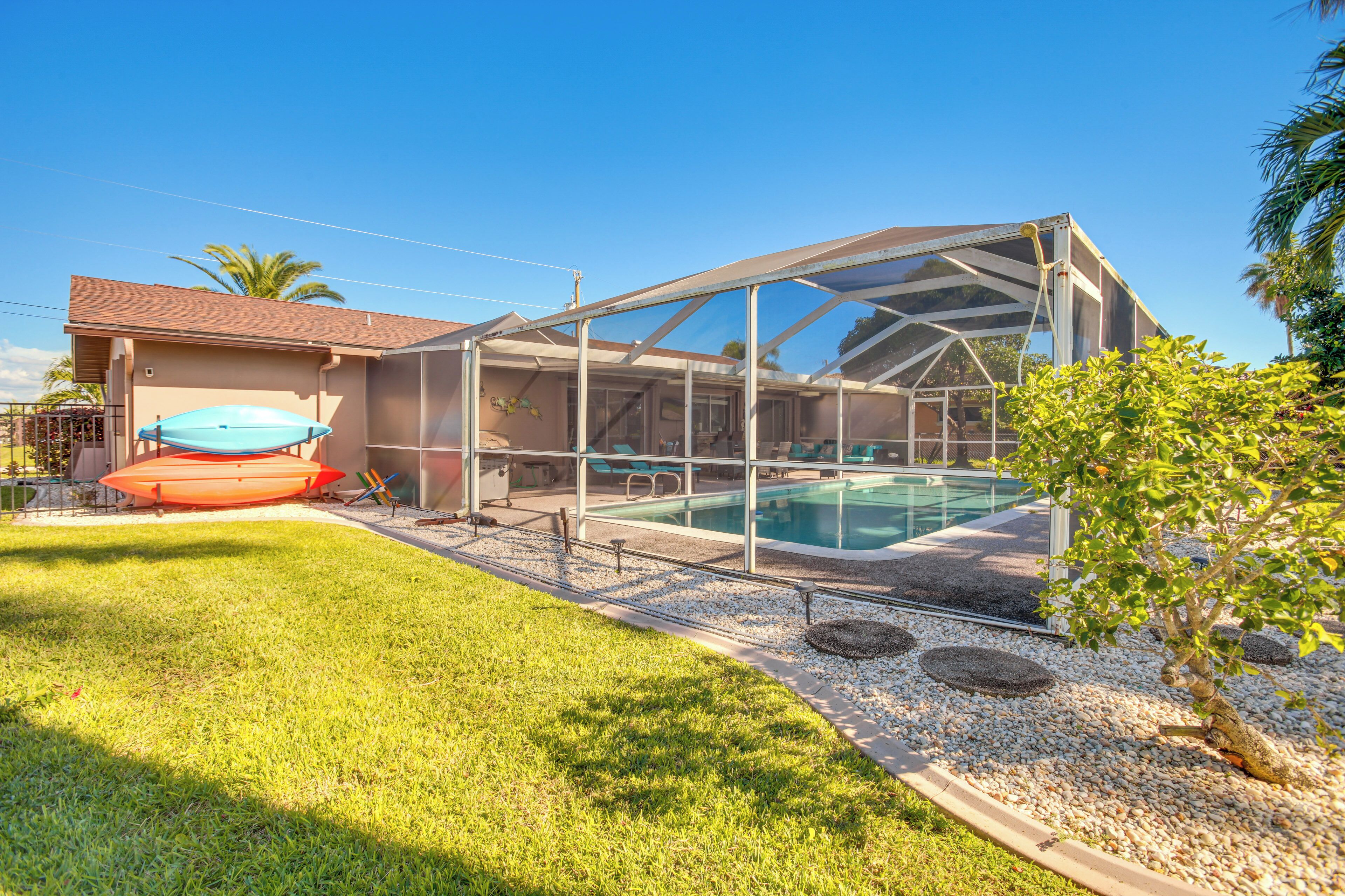 A house with a swimming pool, covered patio, and a boat.