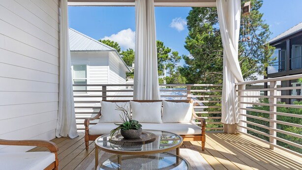 A covered outdoor seating area with a sofa, two glass-top tables, and a wooden bench. - Beachside Haven w/ Firepit, BBQ & Pool Access | Driftwood Dreams by AvantStay (Inlet Beach)