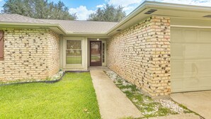 A two-story house with a brick exterior, a front door, and a garage. - Fish, Golf, Explore: Home 3 Mi to Prien Lake Park! (Lake Charles)