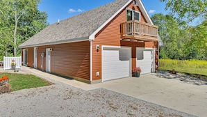 A single-story wooden building with a garage, a balcony, and a well-maintained lawn. - 4 Mi to Downtown Delphi: Trails & Fishing Pond (Delphi)