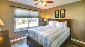 A bedroom with a bed, a ceiling fan, a window with blinds, and two framed pictures on the wall. - Sip, Soar & Explore: Spacious Union Home w/ Yard (Union)