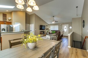 Amplia sala de estar con mesa de comedor, sillas, sofá y televisor.