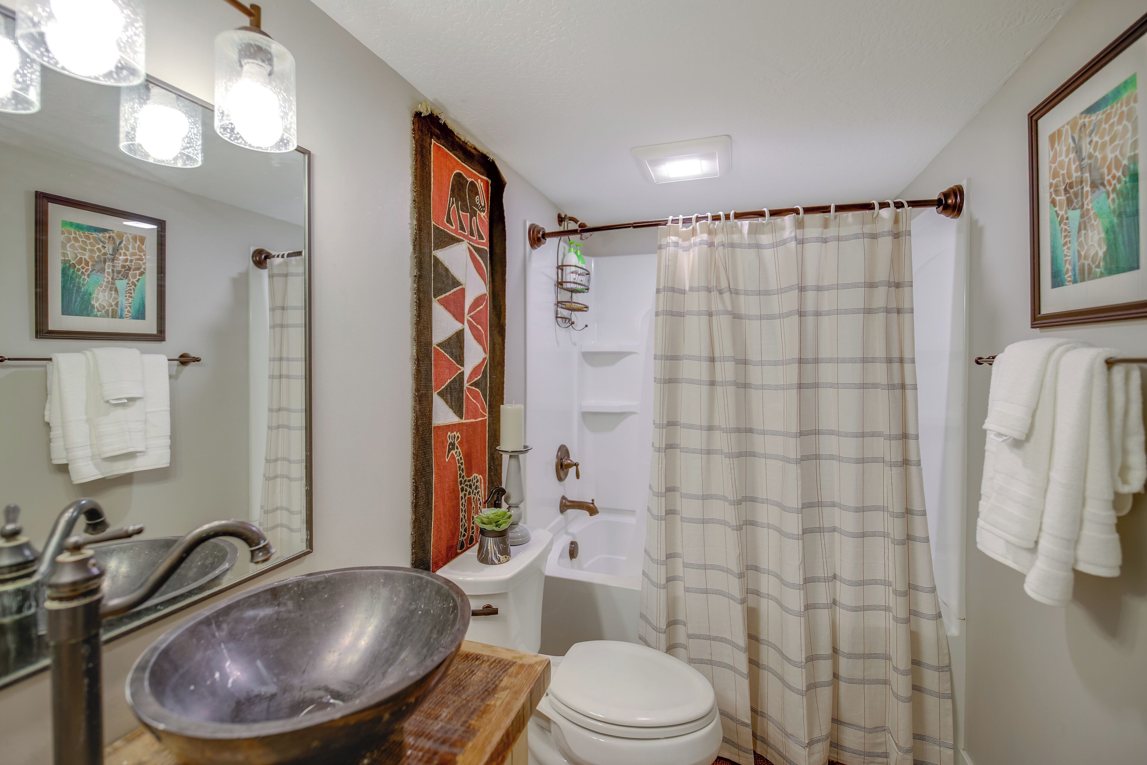A bathroom with a sink, toilet, and shower curtain.