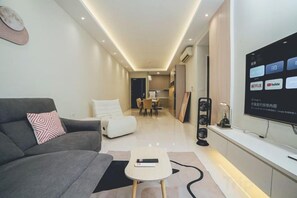 Una sala de estar moderna con un sofá, una mesa de centro y un televisor de pantalla plana montado en la pared.