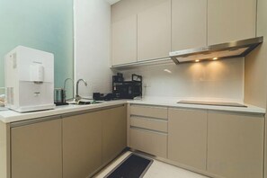 Una cocina moderna con cafetera integrada, microondas y campana extractora de acero inoxidable.