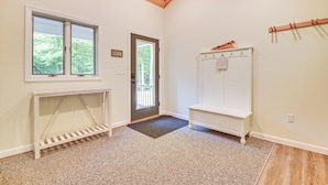 A room with a wooden ceiling, a white bench, a white cabinet, and a door leading outside. - Hike, Leaf-peep, Ski: Hideaway w/ Private Hot Tub! (Intervale)