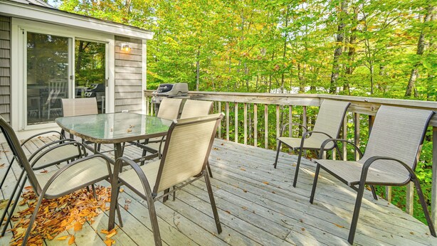 A wooden deck with a glass table and chairs, surrounded by trees. - Hike, Leaf-peep, Ski: Hideaway w/ Private Hot Tub! (Intervale)