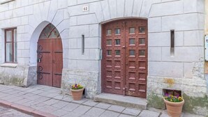 A building with two large wooden doors, numbered 62, and a small window to the left. - Stay in a real medieval tower (lower floors) (Tallinn)