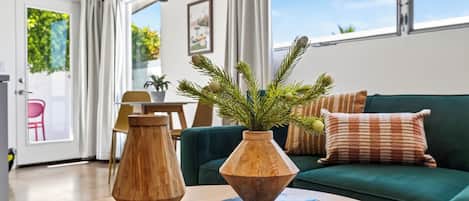 A modern living room with a wooden coffee table, a wooden vase, and books.
