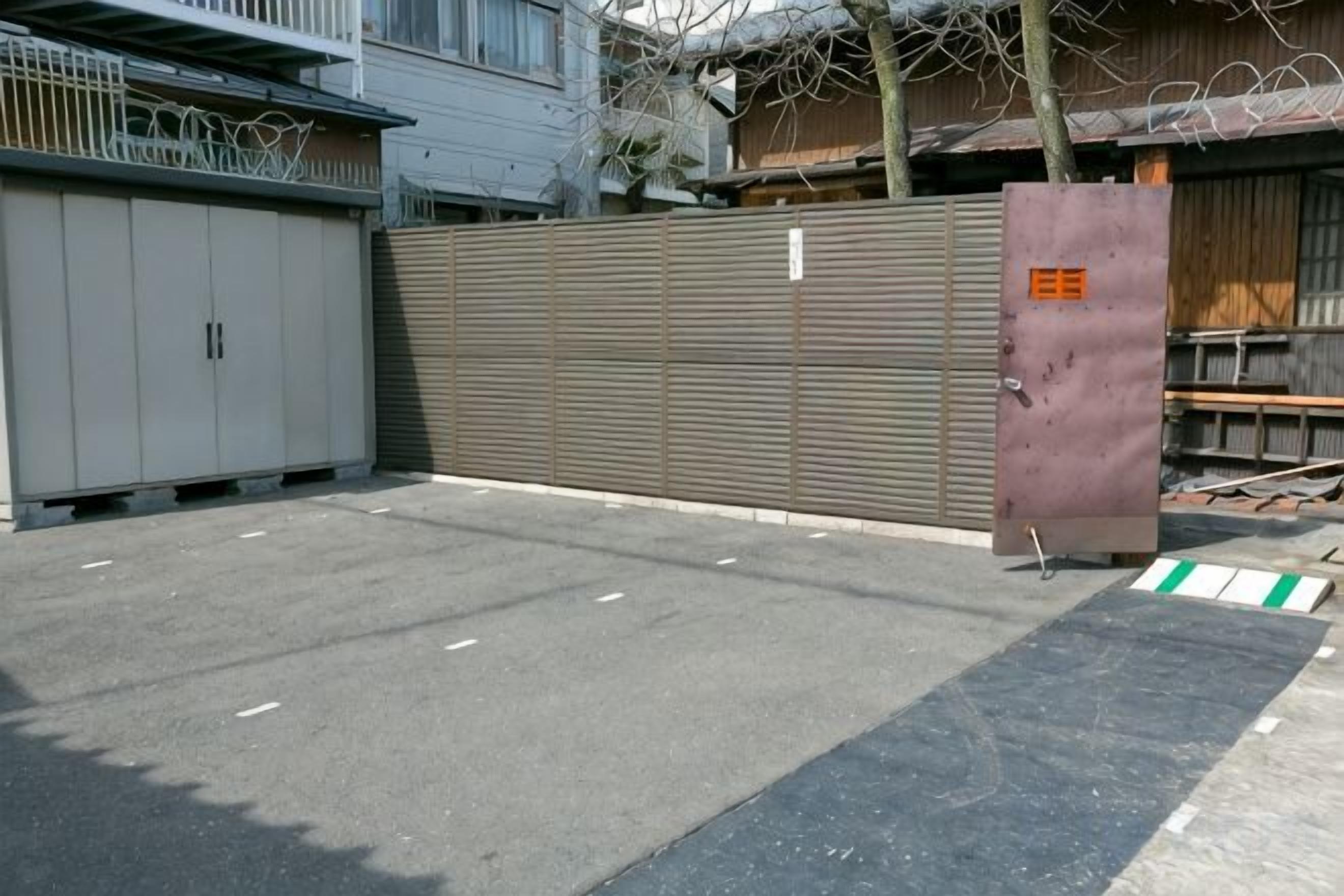A gated parking area with a metal fence and a large metal gate.
