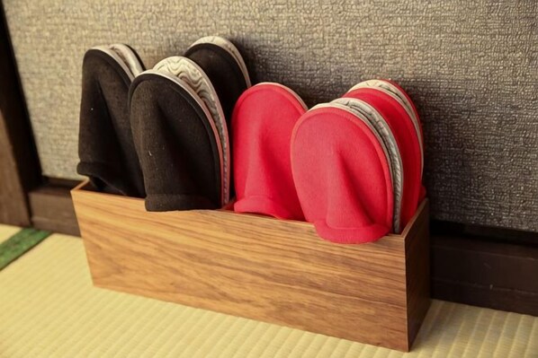 A wooden shoe rack with slippers.